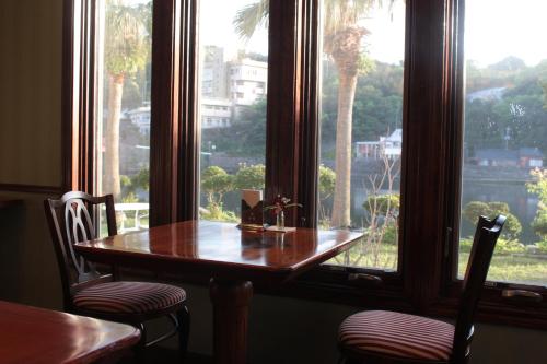 屋久島にあるLA・ISLA・TASSEの窓際の木製テーブルと椅子
