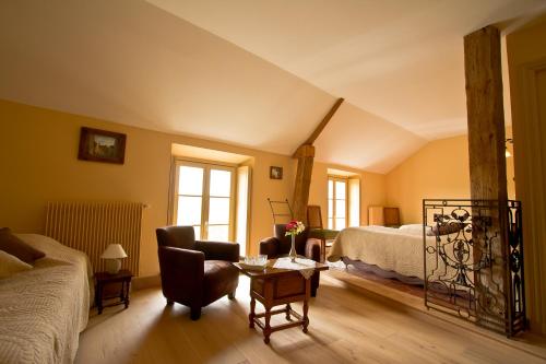 a bedroom with a bed and a couch and a table at La petite Ferme in Chérence