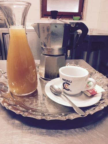Collebrincioni的住宿－Un Passo Dal Cielo，盘子,盘子上装有咖啡杯和一壶果汁