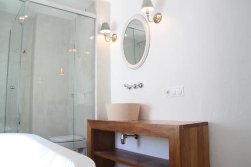 a bathroom with a shower and a sink and a mirror at S'Esparteria Hotel in Ciutadella
