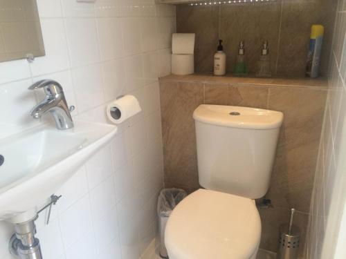 Łazienka z białą toaletą i umywalką w obiekcie Studio Apartments Camden Town w Londynie