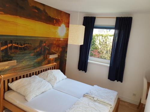 ティメンドルファー・シュトラントにあるFerienwohnung Ostsee23のベッドルーム1室(壁に絵画が描かれたベッド1台付)