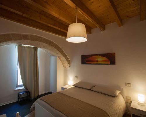 a bedroom with a bed in a room with wooden ceilings at Dimora Nonna Rosa in Conversano