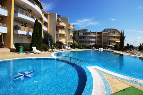 a large swimming pool in front of some apartment buildings at Apartments Lucky Complex Ravda in Ravda