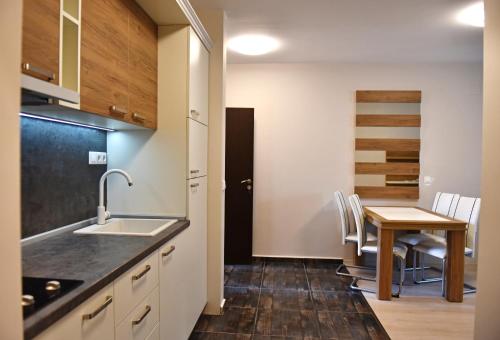 una cucina e una sala da pranzo con tavolo e sedie di Apartments Lucky Complex Ravda a Ravda