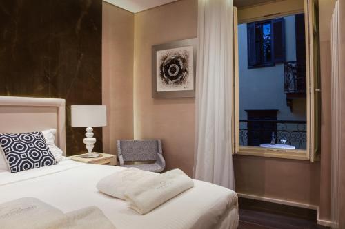 a bedroom with a bed and a window and a chair at Consolato Boutique in Chania