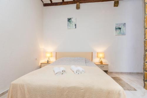 a bedroom with a bed with two towels on it at Stari Grad in Krk