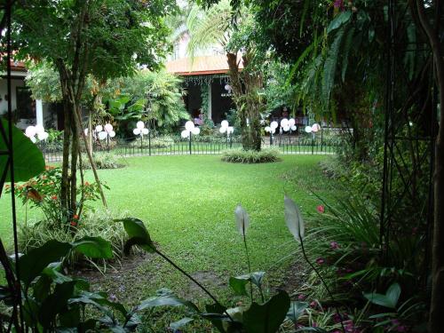 a garden with white chairs and a fence at Hotel Casa Duranta in Cobán