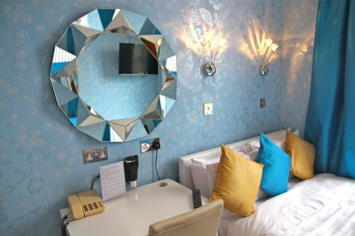 a bedroom with a bed with a mirror and a mirror at Crompton Guest House in Hounslow