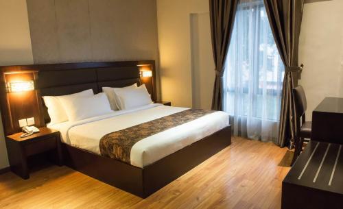 a bedroom with a bed and a large window at Castello Hotel in Kulai