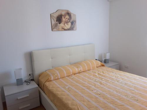 ein Schlafzimmer mit einem Bett mit einem Bild an der Wand in der Unterkunft Appartamento Poggio Romantico in Marciana