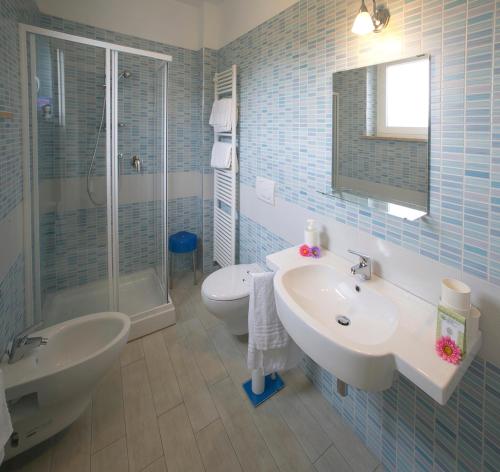 uma casa de banho com um lavatório, um chuveiro e um WC. em Giglio Del Conero em Numana