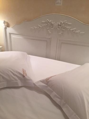 a white bed with a white headboard and white pillows at Stampalia Luxury Studios in Astypalaia Town