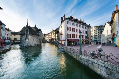 une rivière au milieu d'une ville avec des bâtiments dans l'établissement Le Cocon - 3 étoiles, à Annecy