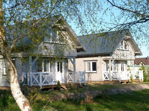 a white house with a fence in front of it at Cztery Pory Roku in Trzęsacz