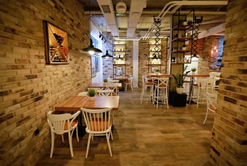 a room with tables and chairs and a brick wall at Apartmani Olimpus in Banja Luka