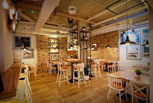 a restaurant with tables and chairs and a brick wall at Apartmani Olimpus in Banja Luka