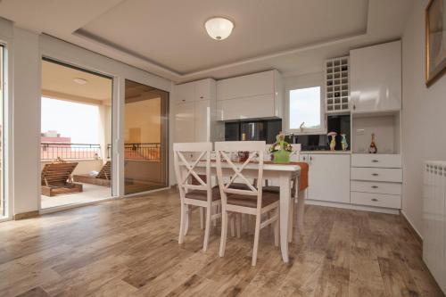 a kitchen with a table and chairs in a room at Guest House Medin in Petrovac na Moru