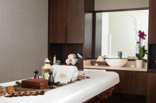 uma casa de banho com um lavatório e um balcão com uma banheira em Jumeira Rotana – Dubai em Dubai