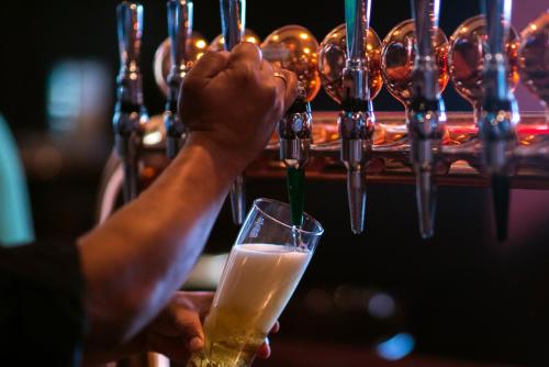 a person is holding a glass of beer at Jumeira Rotana – Dubai in Dubai