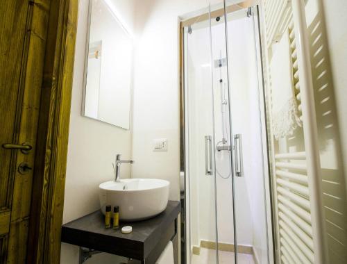 y baño con lavabo y ducha acristalada. en Palazzo Cavoti, en Galatina