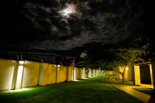 a long alley with a fence at night with the moon at Africanos Country Estate in Addo
