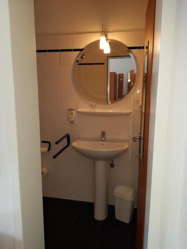 Hotel Havenhaus في بريمن-فيغِزاك: حمام مع حوض ومرآة