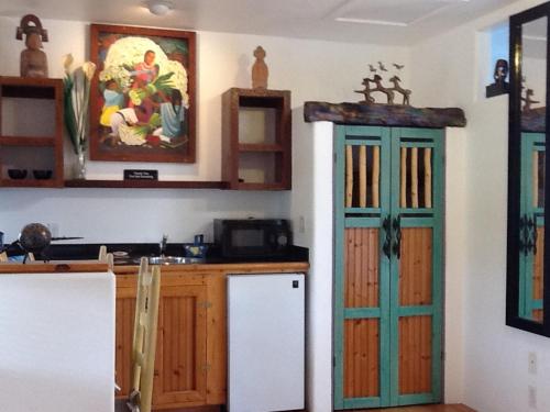 a kitchen with a white refrigerator and a green door at Les Artistes Inn in San Diego
