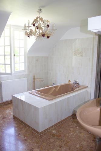 une grande salle de bain avec une baignoire et un lavabo dans l'établissement L'Hermitage, à Saint-Martin-des-Champs