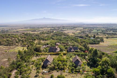 an aerial view of a village with mountains in the background at Rhino Watch Safarilodge in Mweiga