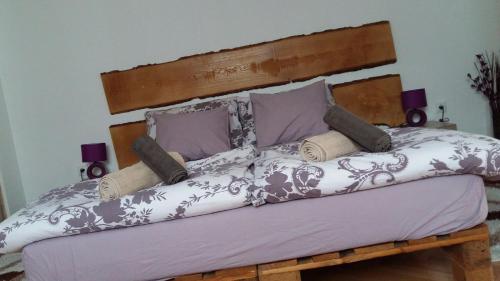 uma cama com lençóis e almofadas roxos e brancos em Apartmani Stonewood em Zagreb