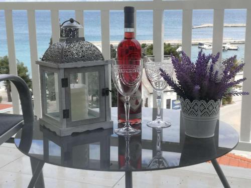 una mesa de cristal con una botella de vino y copas de vino en Apartments Panorama, en Trpanj