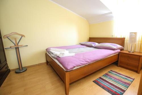 a bedroom with a bed with purple sheets and pillows at Apartmani Ljubica in Poreč