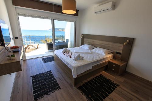 een slaapkamer met een bed en uitzicht op de oceaan bij Apartmani Capri in Sutomore