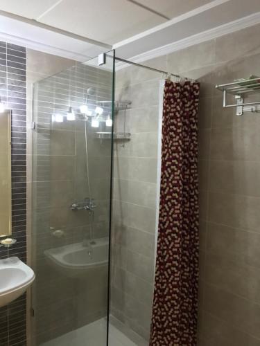 a bathroom with a glass shower and a sink at Appartement Bellavista - Cabo Negro in Cabo Negro