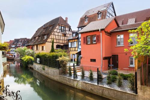 a river with houses and boats in it at Hotel Le Colombier Suites in Colmar