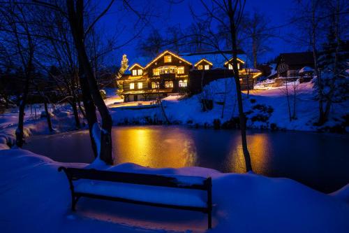 a house in the snow at night with a bench at Chata Pod lipami in Rokytnice nad Jizerou