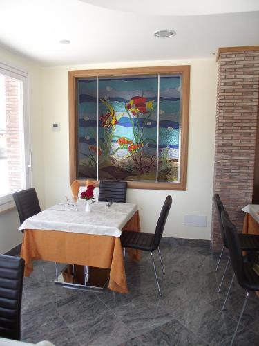 a dining room with a table and a painting on the wall at Il Girasole in Terracina