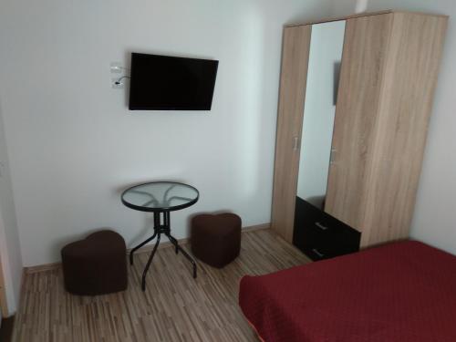 コンスタンツァにあるVila Arisaのベッドルーム(ベッド1台、テーブル、テレビ付)