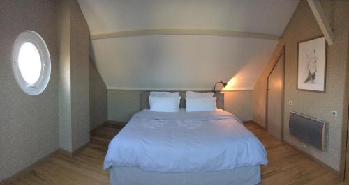 um quarto com uma grande cama branca e uma janela em Holiday Home Castle View em Pierrefonds