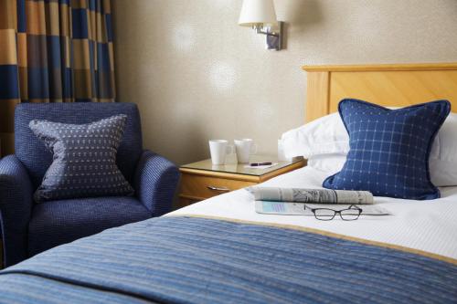 a bed with two pillows and a laptop on it at Pomme d'Or Hotel in Saint Helier Jersey