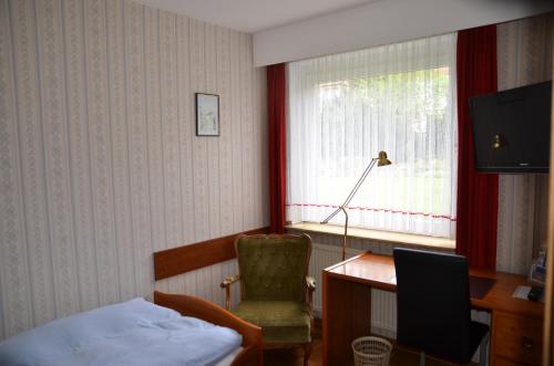Schlafzimmer mit einem Bett, einem Schreibtisch und einem Stuhl in der Unterkunft Hotel Waldersee in Hannover
