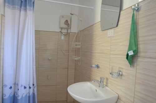 La salle de bains est pourvue d'un lavabo et d'une douche. dans l'établissement Captain's Lodge and Bar, à Panglao