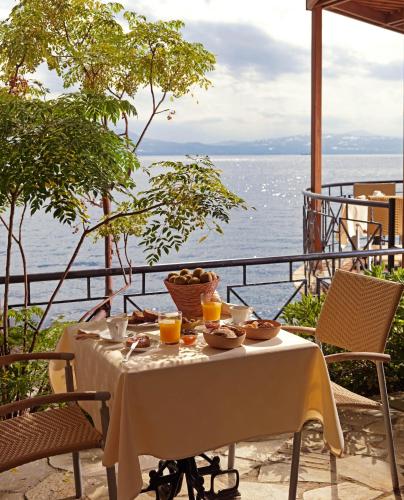 una mesa con un bol de fruta y zumo de naranja en Ramada Loutraki Poseidon Resort, en Loutraki