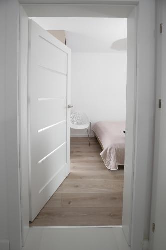 an open door to a bedroom with a bed at 100-SIO Apartamenty in Koszalin