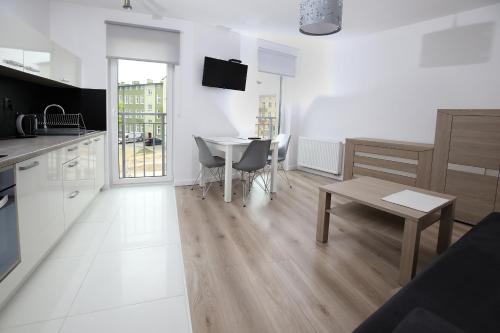 a kitchen and dining room with a table and chairs at 100-SIO Apartamenty in Koszalin