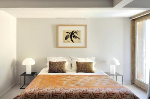 サン・マルタン・ド・ベルヴィルにあるHome by U - Chalet 2の白いベッドルーム(ランプ2つ付きの大型ベッド1台付)