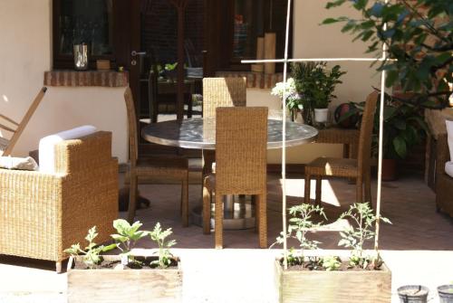 um pátio com uma mesa, cadeiras e plantas em Studio Sforzesco em Bellinzago Novarese