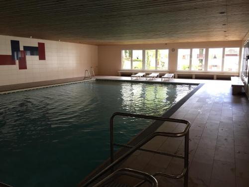 a large swimming pool with chairs in a building at Ferienwohnung Familie Zuck in Missen-Wilhams