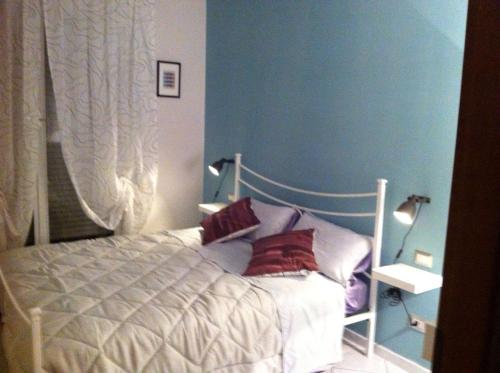 een slaapkamer met een wit bed met rode kussens bij Appartamento al Parco CIR03407AT00243 in Parma